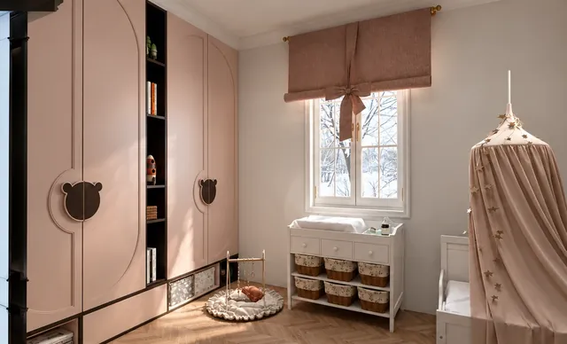 Babyzimmer mit rosa Schrankfronten, Wickelkommode mit Körben, Raffrollo mit Schleife und Betthimmel